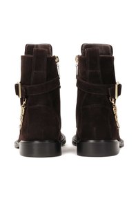 Botas de tobillo de ante marrón oscuro con un acabado suave, que cuentan con cremalleras laterales, acentos en dorado y una suela de goma plana.