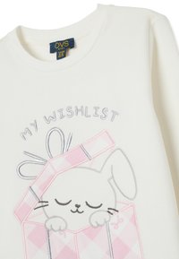 Sudadera blanca de manga larga con un conejito saliendo de una caja de regalo rosa, con "MI LISTA DE DESEOS" bordado arriba en hilo gris y negro.