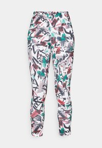 Enganliegende Leggings mit einem bunten abstrakten Muster in Rot, Grün und Schwarz auf weißem Hintergrund. Hergestellt aus dehnbarem Material.