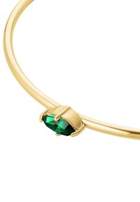 Zlatni bangle sa ovalnim zelenim dragim kamenom postavljenim u stegu nalik pandžama, glatka tekstura sa poliranim završetkom.