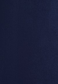 Close-up of dark blue textured fabric with tightly woven threads and subtle variations in shading.