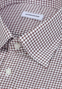 Chemise blanche avec un petit motif à carreaux marron, dotée d'un col classique et d'une fermeture à un bouton, avec une étiquette « seidensticker ».