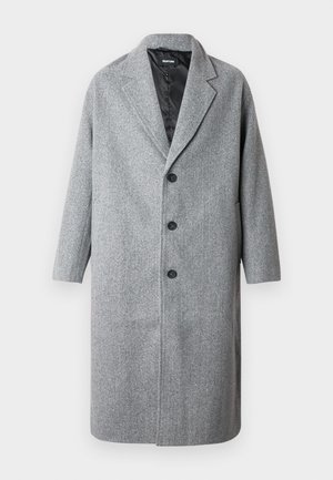 Cappotto grigio in lana con design sartoriale, caratterizzato da un colletto a lancia, tre bottoni e due tasche laterali. La texture è liscia e morbida.