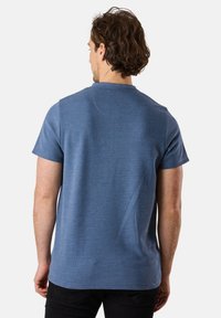 Short-sleeve blue t-shirt with a ribbed texture, round neckline, and a straight hem, viewed from the back. Black pants visible.