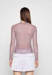 Top ajustado de manga larga fabricado en tela transparente, que presenta un patrón geométrico en rosa y púrpura y un escote redondeado.