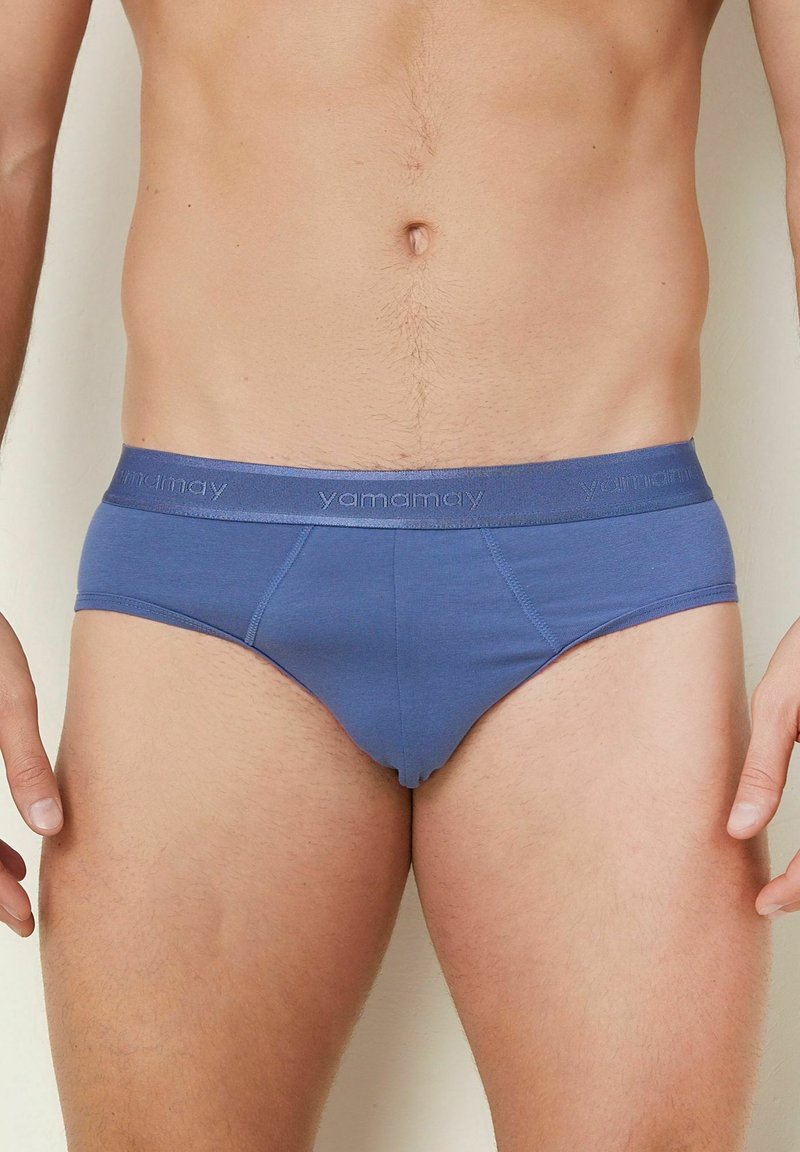 Men's briefs in solid blue fabric with a soft, elastic waistband featuring the logo "yamamay." Designed for comfort and a snug fit.