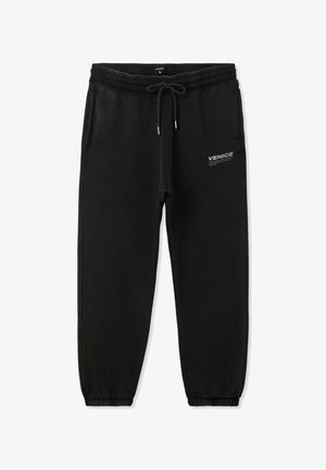 Czarne dresy wykonane z miękkiego materiału, z elastycznym pasem w talii i sznurkiem do regulacji, zwężanymi nogawkami oraz białym logo "VENICE" po boku.