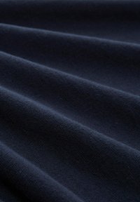 Donker marineblauwe stof met een gladde, zachte textuur, met subtiele golvingen en een gelijkmatige, consistente weving overal.