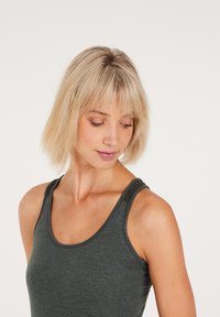 Dunkelgraues, tailliertes Tanktop mit breiten Trägern und dekorativer Naht. Glatte Textur, Rundhalsausschnitt und zurückhaltendes Design.