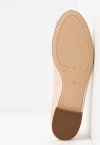 Semelle de chaussure en cuir rose clair avec un talon et une semelle extérieure marron clair, marquée taille 4 1/2, avec le nom de la marque "högl" visible sur la semelle.