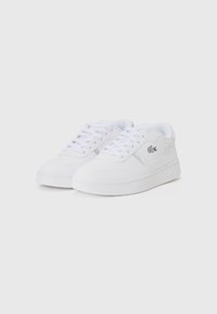 Hvite sneakers med en glatt overflate, rund tå, flat gummisåle og snøring. Har et lite brodert logo på siden.