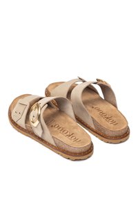 Sandali in suede beige con due ampi cinturini e un'infiorescenza in metallo dorato. Soletta in sughero sagomata e suola in gomma con cuciture decorative.