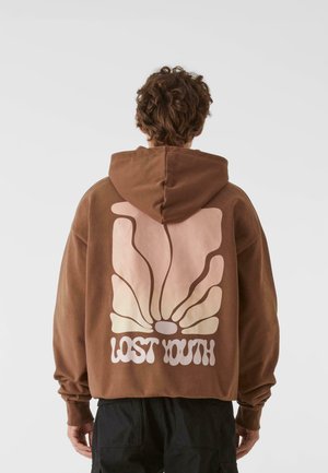 Brązowy hoodie z kapturem, ozdobiony dużą, stylizowaną grafiką motyla w odcieniach różu i kremu, z napisem "ZAGUBIONA MŁODZIEŻ" poniżej wzoru.