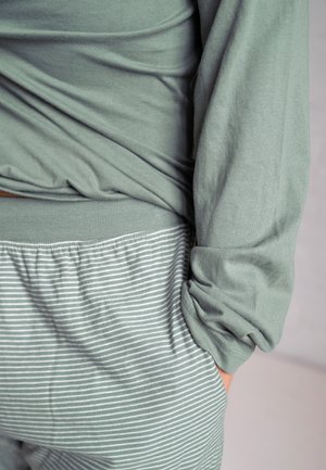 Groene katoenen longsleeve top met een relaxte pasvorm en omgeslagen mouwen, gecombineerd met zachte, lichtgroene gestreepte joggers met elastische taille.