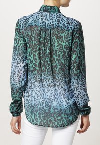 Blusa a maniche lunghe, trasparente, in gradiente di verde e blu con stampa leopardata nera. Presenta un colletto con bottoni e un dettaglio arricciato sul retro.