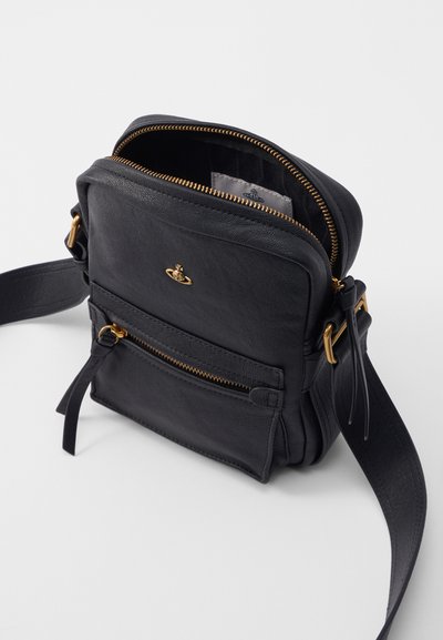 Černá kožená crossbody taška se zlatými kovovými prvky, dvěma zipovými kapsami a textured povrchem. Nastavitelný popruh pro všestranné možnosti nošení.