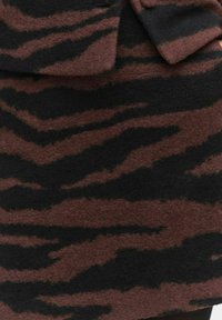 Brun och svart imitation päls med ett tigerstripemönster, med en mjuk textur och en skräddarsydd design med ett något klumpigt utseende.