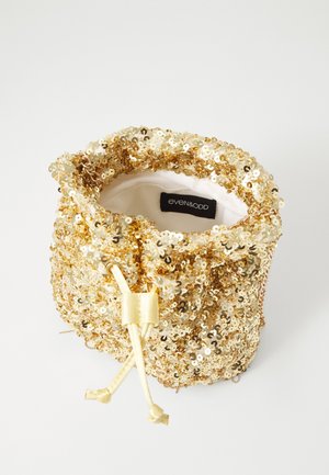 Lille guld palietpose med snøre, cremefarvet stofindvendigt og guldkædet detalje, mærkelabel "even&odd" synlig indeni.