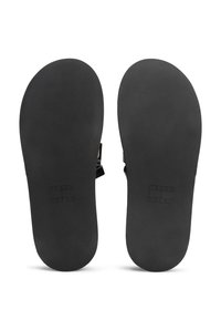 Tongs noires avec une semelle en caoutchouc lisse, un design minimaliste et un logo en relief sur la semelle intérieure. Pas d'ornements supplémentaires.