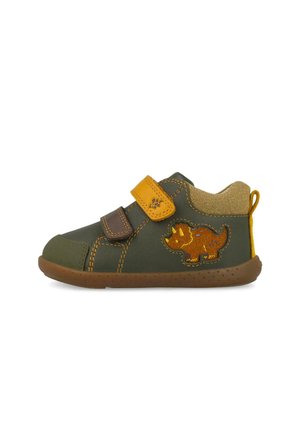Zapato infantil de color verde oscuro con suela marrón, tiras de velcro amarillas y marrones, y una parche de dinosaurio amarillo y marrón en el lateral.