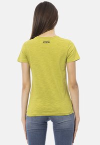 T-shirt a maniche corte, slim-fit, di colore verde chiaro, con collo rotondo e texture sottile. Sul retro è presente il logo "TRUSSARDI ACTION" in nero.