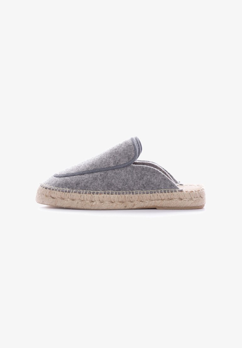 Zapatilla gris de felpa con puntera redondeada, suela de cuerda de yute y detalles cosidos a lo largo del borde superior. Diseño plano adecuado para uso en interiores.