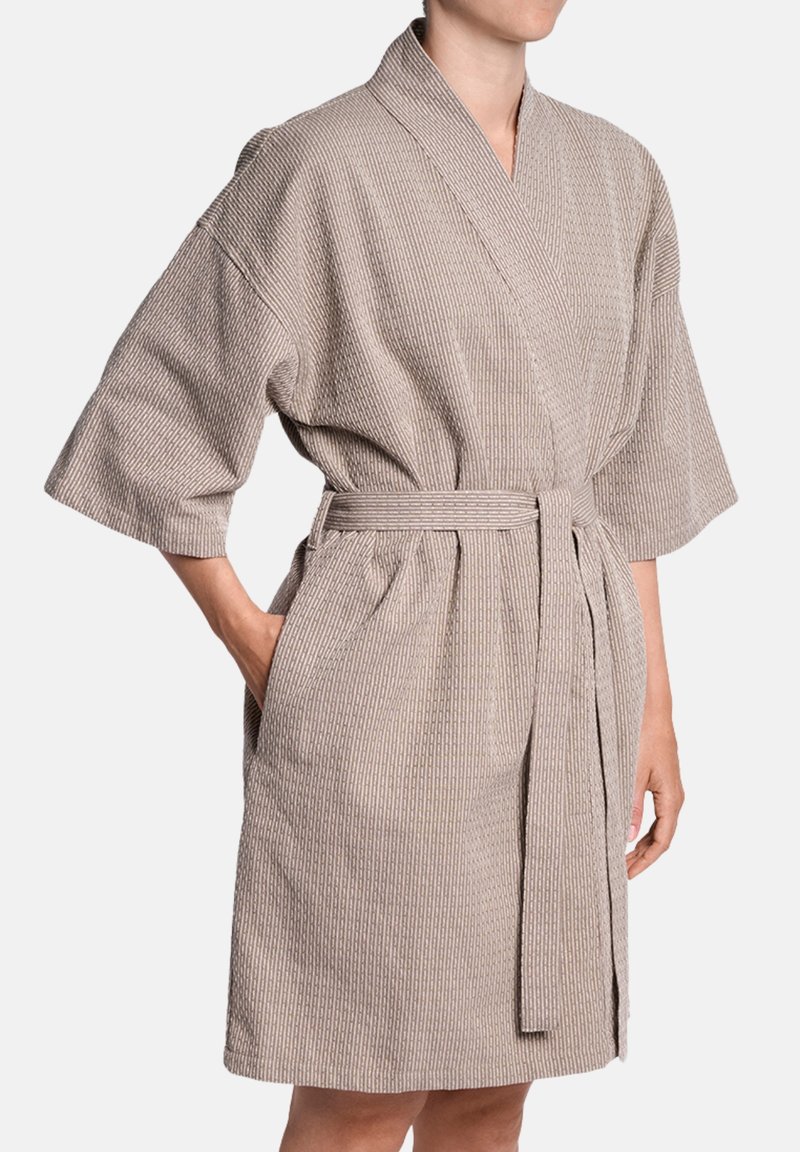 Kimono stila halāts taupe krāsā ar faktūru, ribotu rakstu, platām piedurknēm, jostu viduklī un sānu kabatām. Īsā garumā.