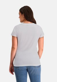 Witte T-shirt met korte mouwen, voorzien van een ronde hals en zachte stof. De achterkant toont een gladde textuur en een aansluitende silhouet.