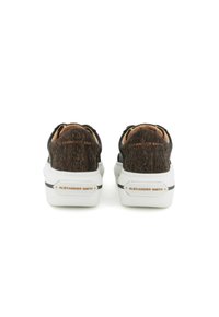 Sneaker neri e marroni con retro testurizzato, suola bianca e branding sottile. Presentano un design sportivo con accenti a contrasto.