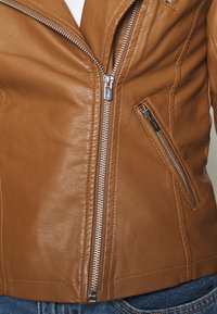 Brun læderjakke med en tætsiddende pasform, udstyret med lynlås foran, sidelomme med lynlås og glat tekstur.