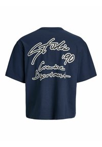 Marineblå kort t-skjorte laget av bomull, med hvit håndskrevet tekst på baksiden: "Studio '90 Creative Department."