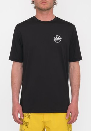 Camiseta negra de manga corta hecha de un tejido suave, con un logotipo gráfico blanco en el lado izquierdo del pecho y un diseño de cuello redondo.