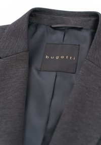 Grau blazer mit einer glatten Textur, verfügt über ein schwarzes Innenfutter. Das Etikett trägt in goldener Schrift auf einem schwarzen Tag "bugatti".