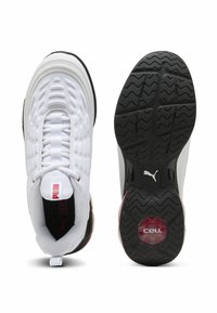 Weiße Sportschuhe mit einem Obermaterial aus Mesh, strukturierten Mustern, einem auffälligen Schnürsystem, einer schwarzen Außensohle mit einem ausgeprägten Profil und roten Akzenten.