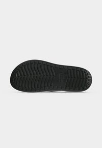 Μαύρη καουτσούκ σόλα παπουτσιού Crocs με υφασμένο σχέδιο πέλματος και λογότυπο Crocs ανάγλυφο στο κέντρο.