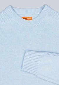 Hellblauer Strickpullover mit ribbeltem Rundhalsausschnitt und Bündchen, glatter Textur und einem kleinen Markenetikett in Orange.