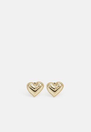 Paire de boucles d'oreilles clous en forme de cœur, dorées et polies, avec un logo gravé subtil sur un fond blanc uni.