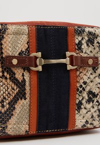 Borsa con motivo a serpente caratterizzata da dettagli in pelle marrone, pannelli in suede blu navy e chiusura in metallo dorato a forma rettangolare.
