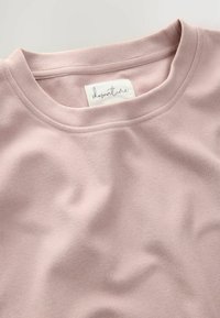 Lichtroze T-shirt met korte mouwen, gemaakt van zachte, gestructureerde stof, met een ronde halslijn en een waslabel aan de binnenkant.