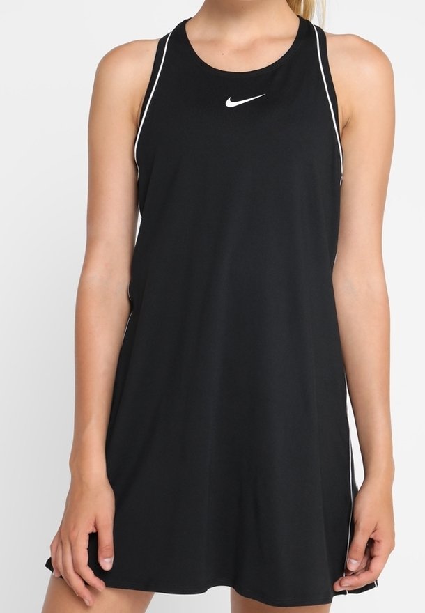 Femme portant une robe Nike noire sans manches avec des liserés blancs et un petit logo Nike blanc sur la poitrine.