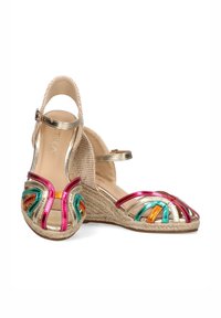 Sandalias de cuña con suela de yute natural, con correas metálicas multicolores en rosa, verde y naranja, y una correa dorada en el tobillo.