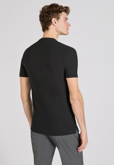 Zwarte T-shirt met korte mouwen en een ronde halslijn, met een soepele textuur en een minimalistisch ontwerp. Heeft een normale pasvorm en subtiele zijsplitten.