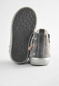 Szare zamszowe buty typu high-top z miękką podszewką, kauczukowa podeszwa w gwiazdy oraz ozdobne kokardy. Metaliczne akcenty podkreślają design.