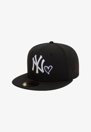 Melnā kokvilnas cepure ar plakanu vizu. Ievērojama ar baltu izšūtu "NY" logo un sirds detaļu, kā arī sarkaniem un baltajiem akcentiem sānos.