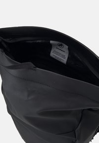 Sac à dos noir avec une texture lisse, fermeture à glissière sur le dessus et une étiquette intérieure. Présente un matériau robuste et un design minimaliste.