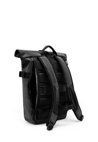 Mochila negra tipo roll-top con respaldo de malla acolchada, correas ajustables y bolsillo exterior con cremallera. Fabricada con material duradero y acentos mínimos.