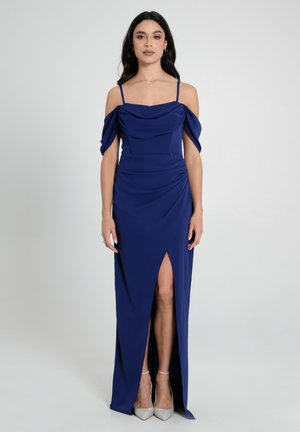 Abito da sera blu navy con maniche drappeggiate off-the-shoulder, corpetto aderente e uno spacco alto alla coscia, realizzato in tessuto liscio e vellutato.