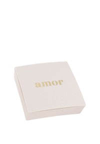 Scatola quadrata di colore rosa pallido con una superficie liscia e un design del testo "amor" in oro sul coperchio. Minimalista, senza hardware o accenti visibili.