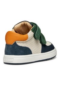 Sneaker per bambini Geox con tomaia beige perforata, dettagli in suede blu navy, cinturino in velcro verde e particolare arancione sul tallone. Suola bianca.
