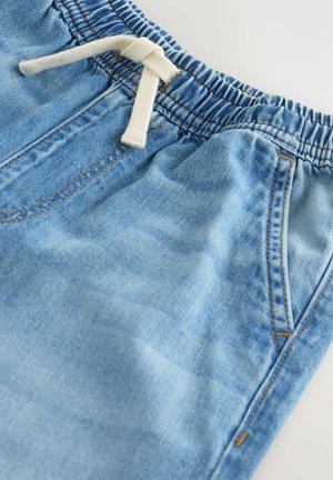 Pantaloni din denim albastru deschis, cu talie elastică și șnur alb, prevăzuți cu buzunare laterale și detalii de cusături vizibile.